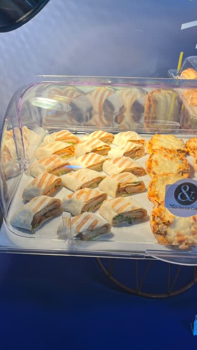 Grilled chicken wraps and cheese pastries on a catering tray